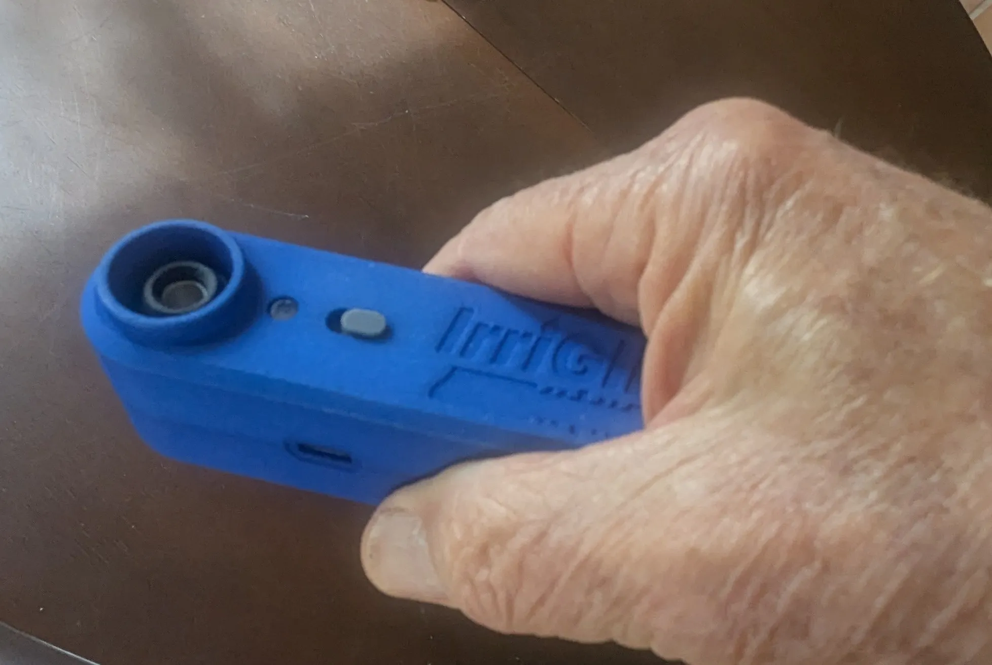 A hand holding the IrriGlide Slim tool